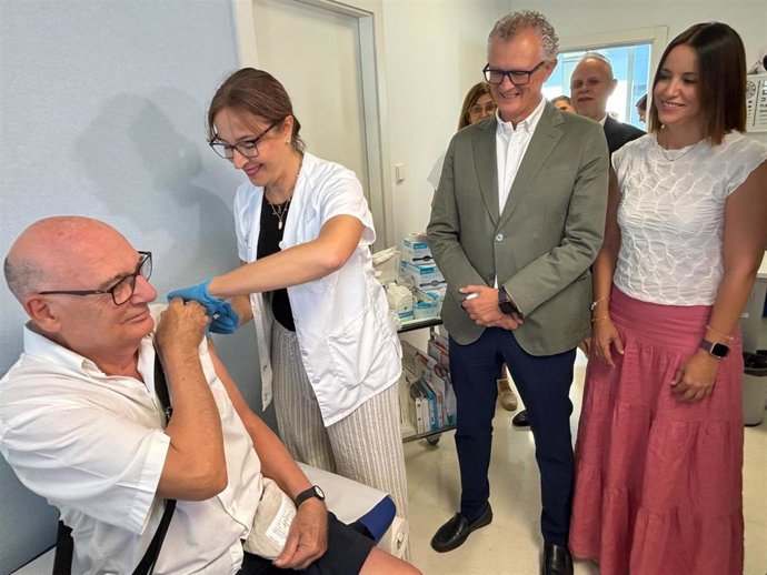 Un hombre recibe la vacuna del neumococo en presencia del consejero de Salud, Juan José Pedreño