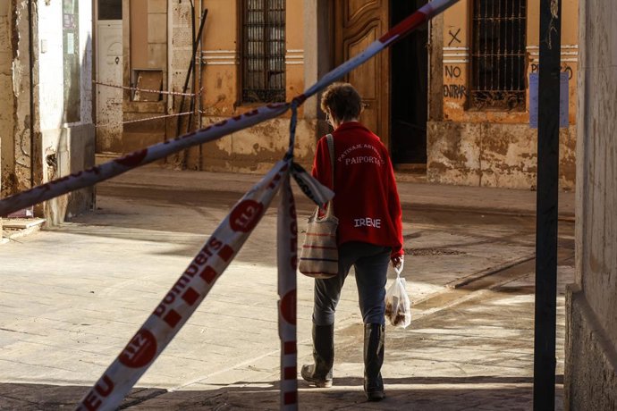 Archivo - Arxiu - Imatge d'arxiu d'una dona que dona camina pel carrer, a 28 de novembre del 2024, a Paiporta, València