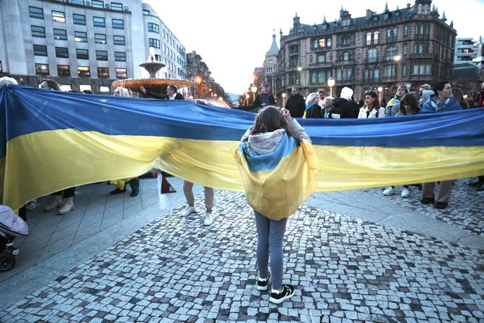 Archivo - Un grupo de personas sujeta una bandera de Ucrania durantea una manifestación contra la invasión rusa de Ucrania