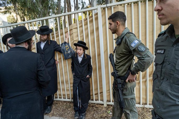 Archivo - Hombres ultraortodoxos junto a agentes de policía durante una protesta frente a un centro de reclutamiento de las Fuerzas de Defensa de Israel en Israel