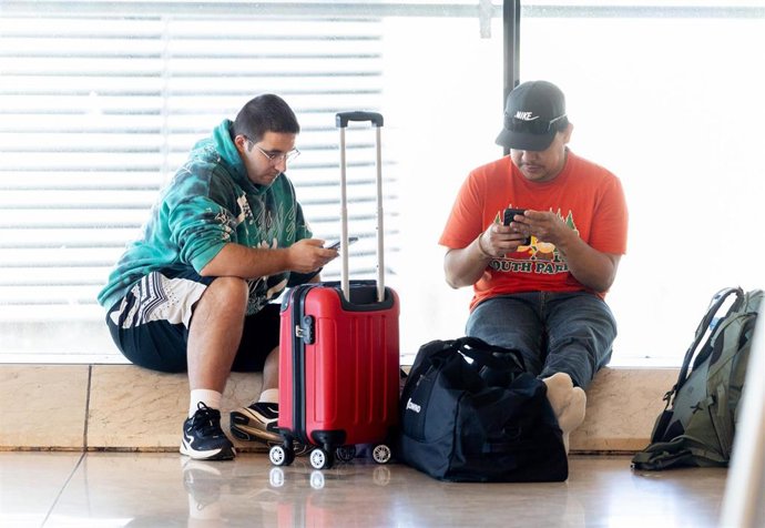 Archivo - Dos personas con maletas.