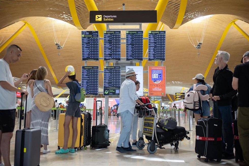 Archivo - Pasajeros con maletas visualizan las pantallas, en el Aeropuerto Adolfo Suárez Madrid-Barajas, a 14 de agosto de 2025, en Madrid (España).  