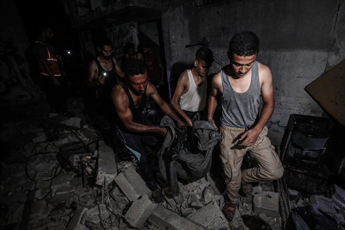 Palestinos trasladan el cuerpo de una víctima de un bombardeo del Ejército de Israel contra el campamento de refugiados de Al Bureij, en la Franja de Gaza (archivo)