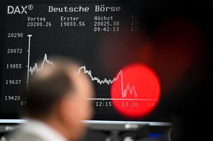 Archivo - 09 April 2025, Hesse, Frankfurt/Main: A trader stands on the trading floor of the Frankfurt Stock Exchange in front of the display board showing the DAX curve. With no solution in sight in the international dispute over tariffs and counter-tarif
