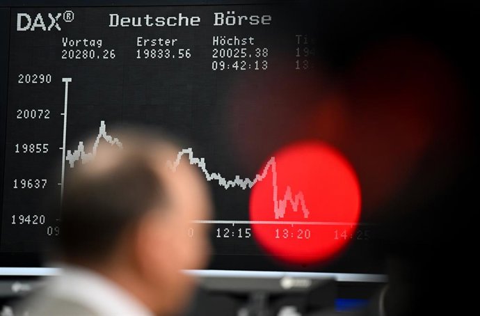 Archivo - 09 April 2025, Hesse, Frankfurt/Main: A trader stands on the trading floor of the Frankfurt Stock Exchange in front of the display board showing the DAX curve. With no solution in sight in the international dispute over tariffs and counter-tarif