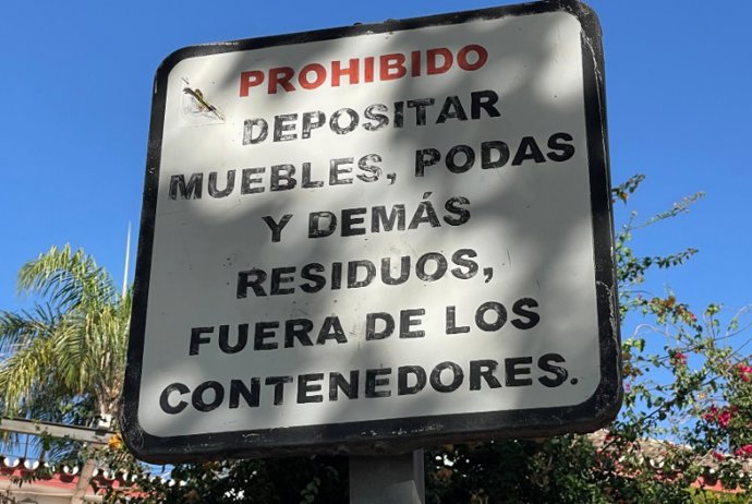 Cartel que recuerda la prohibición de despositar muebles, podas y demás residuos fuera de los contenedores habilitados para ello.