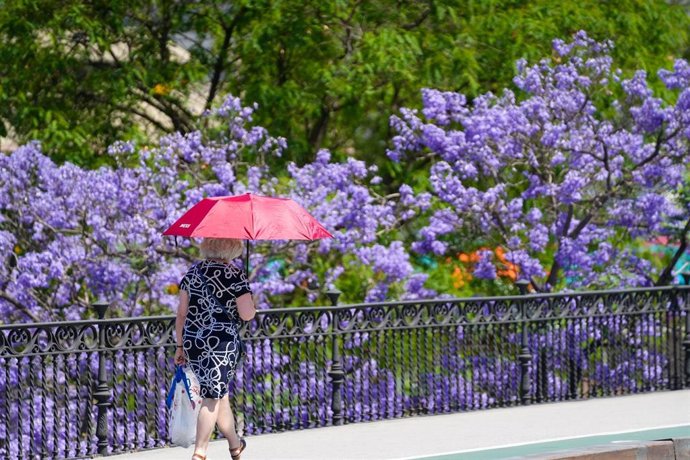 Archivo - Personas con ropa veraniega paseando por el Puente de Triana. A 28 de mayo de 2025, en Sevilla (Andalucía, España).
