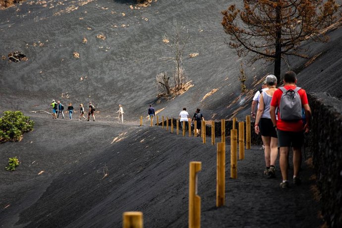 Archivo - Turistas caminan por un sendero afectado por la lava del volcán de Tajogaite, en la Sierra de Cumbre Vieja, La Palma