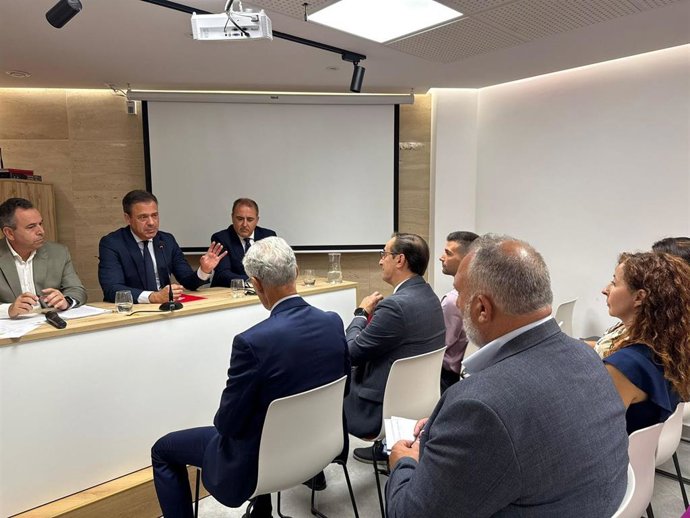 El consejero Marcos Ortuño se dirige a los asistentes a la Comisión de Seguridad Ciudadana de la FMRM acompañado por su presidente, José Antonio Blasco, alcalde de Abanilla, y el director general de Administración Local, Francisco Abril