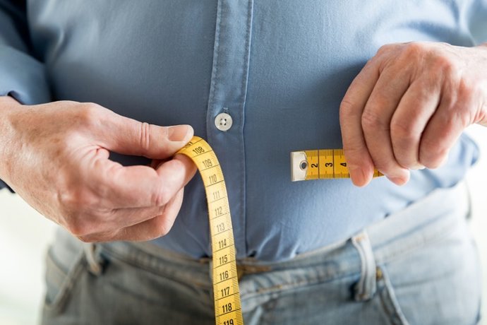 Archivo - Imagen de recurso de un hombre que se mide el abdomen. 