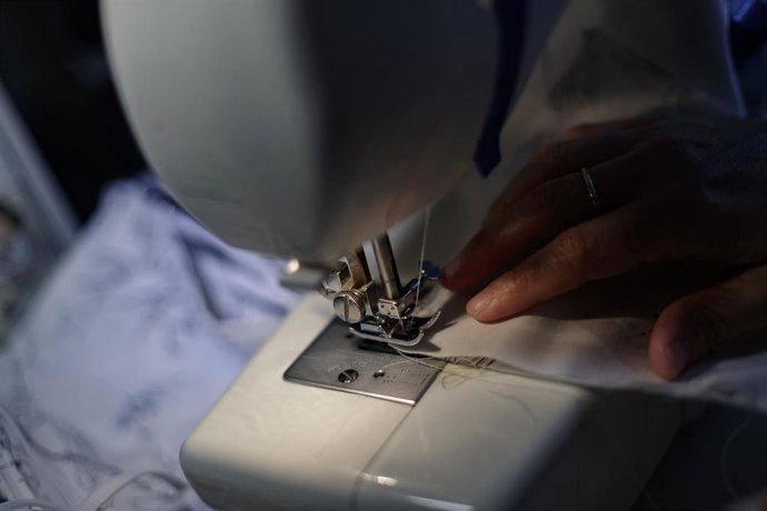 Archivo - Una mujer cose una mascarilla con una máquina de coser dentro de una iniciativa de un grupo de amigas que donará mascarillas para la protección frente al coronavirus, en Madrid (España) a 25 de marzo de 2020.