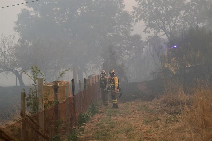 Varios bomberos forestales tratan de extinguir el fuego en Lornís, a 18 de septiembre de 2025, en Pantón, Lugo, Galicia (España). 