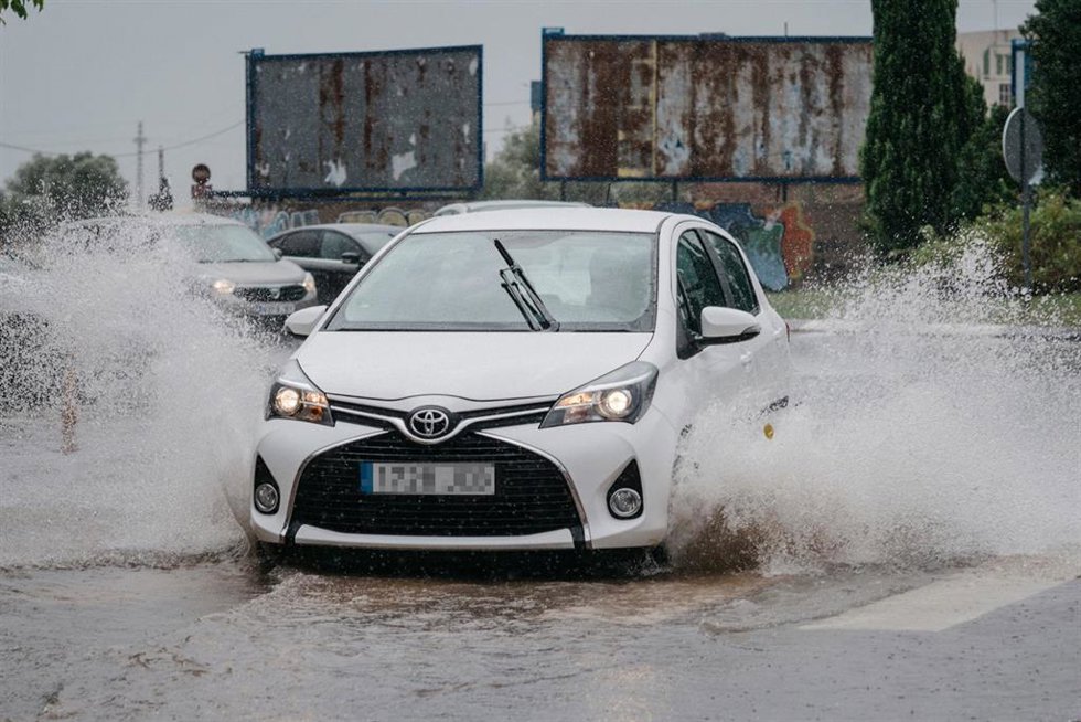 Archivo - Un coche circula bajo la lluvia en Castelló. Imagen de archivo.