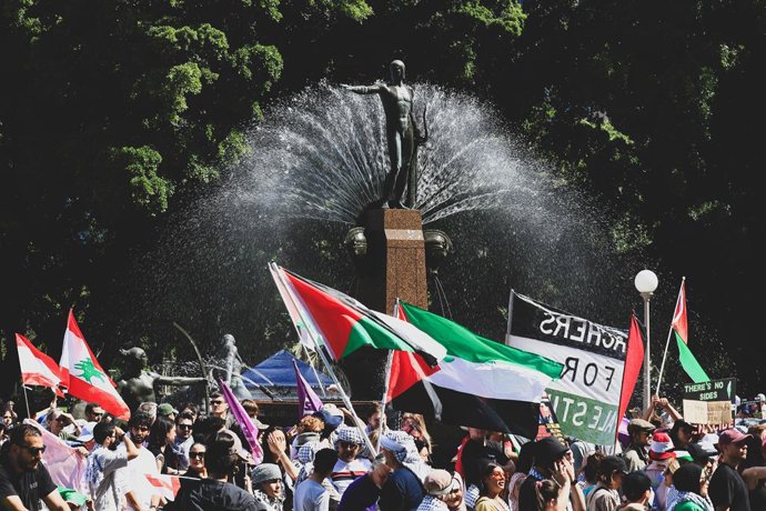 6 de outubro de 2024, Sydney, Austrália: Manifestantes com bandeiras marcham na rua durante a manifestação. Milhares de manifestantes marcharam pelas ruas da cidade para protestar contra a guerra no Oriente Médio, à medida que o aniversário do dia 7 de ou