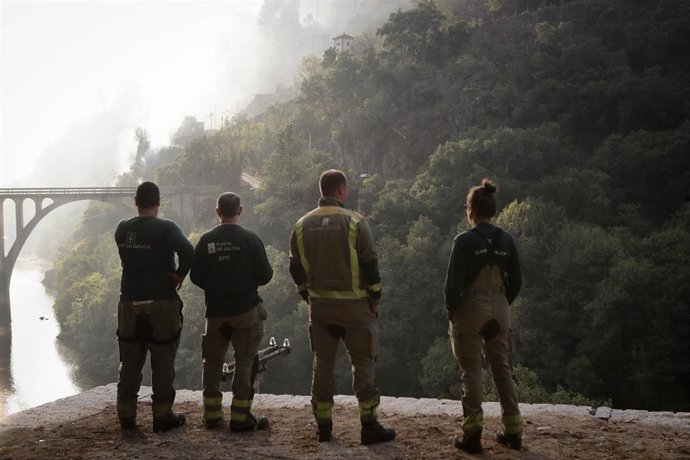Cuatro personas observan el terreno calcinado, a 20 de septiembre de 2025, en A Barca, Sober, Lugo, Galicia (España). 