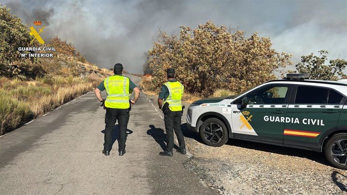 Agentes de la Guardia Civil en una carretera afectada por incendio en Cuacos de Yuste.
