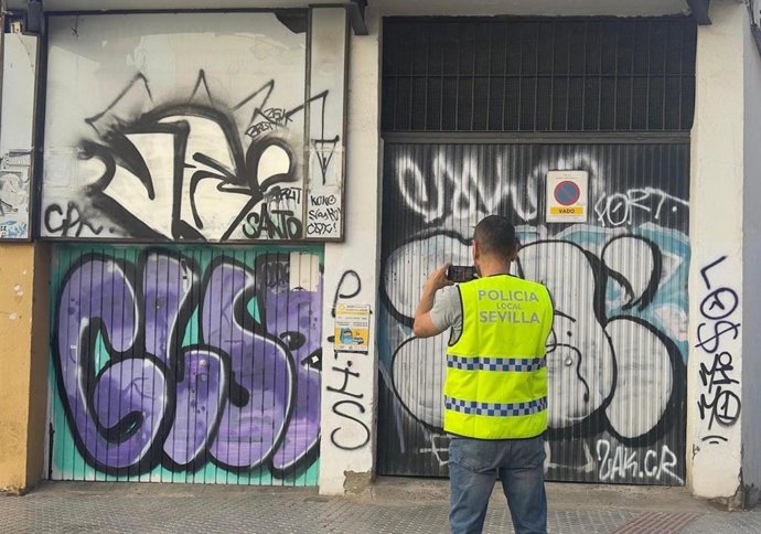 Policía Local junto a grafittis en una fachada.