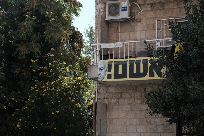 16 de setembro de 2025, Jerusalém, Israel: Uma faixa de Netanyahu em uma sacada residencial com a inscrição: culpado!, enquanto famílias de reféns e apoiadores marcham em direção à residência do primeiro-ministro após invadirem a Conferência Diplomática d