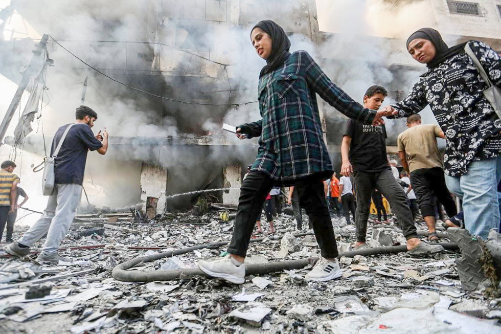 28 September 2025, Palestinian Territories, Gaza: Palestinians move outside a building damaged in an Israeli air strike. Photo: Hasan Alzaanin/TASS via ZUMA Press/dpa
