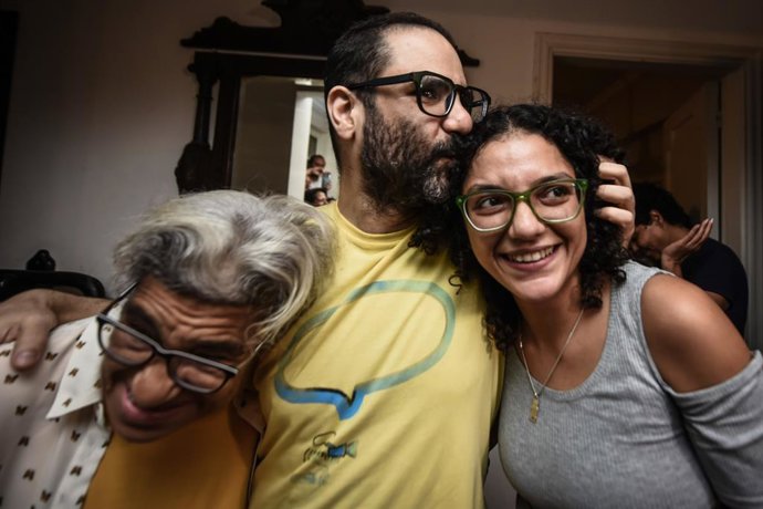 El activista egipcio-británico Alaa Abdelfatá (c) junto con su madre, Leila Seif (i) y su hermana Sanaa Seif (d) tras ser liberado de prisión en Egipto