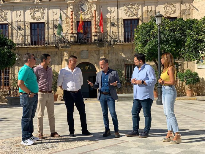 El secretario de Organización del PSOE de Sevilla (4i), en una atención a medios en Lora del Río, acompañado, entre otros, por el portavoz local del PSOE.