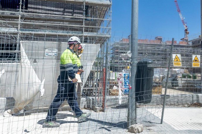 Archivo - Dos obreros trabajan en la construcción de una vivienda nueva, a 29 de julio de 2025, en Madrid (España).
