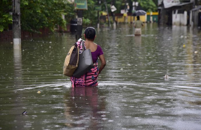 Archivo - Mujer en una calle inundada en India.