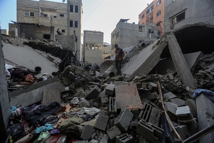 Civiles palestinos entre los escombros de un edificio en la Franja de Gaza