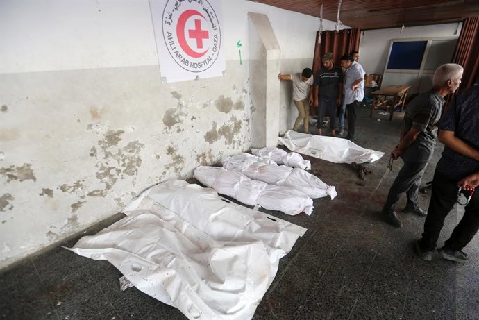 Palestinos no Hospital Al Ahli ao lado de várias pessoas mortas em ataques do exército israelense à Cidade de Gaza, no norte da Faixa de Gaza.