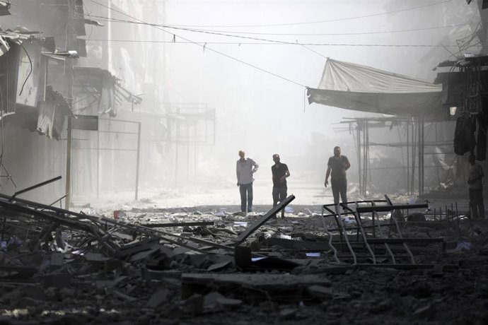 Habitantes de Gaza caminan sobre las ruinas de edificios destruidos por los bombardeos israelíes en Ciudad de Gaza.