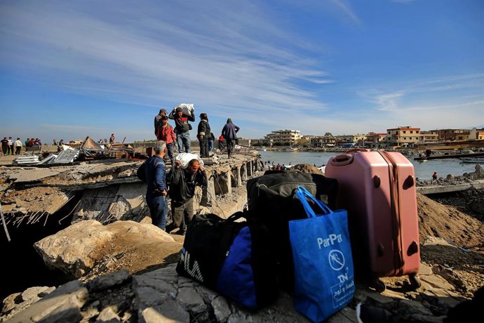 Archivo - Arquivo - 10 de dezembro de 2024, Líbano, Arida: Cidadãos libaneses e sírios cruzam o devastado ponto de fronteira de Arida, ao norte do Líbano, que foi alvo de um ataque israelense na semana passada, separando-o da vizinha Síria. Vários libanes