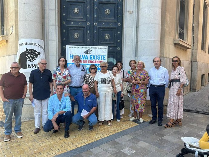 Representantes de la Asociación de Amigos del Museo de Huelva frente al Banco de España.