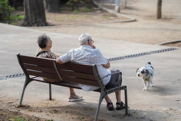 Dos pensionistas en un parque de Cataluña con su perro