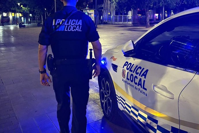 Un agente de la Policía Local de Palma, junto a un vehículo policial, en la zona de la plaza de España. Recurso.