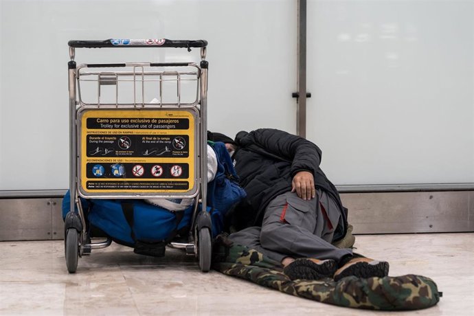 Archivo - Una persona sin hogar en un aeropuerto.