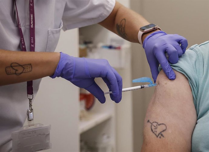 Archivo - Imagen de archivo de una mujer vacunándose durante el inicio de la campaña de vacunación frente a la gripe y la Covid-19 en España.