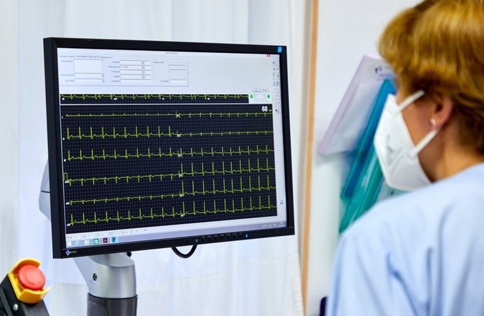 Una sanitaria observa un electrocardiograma