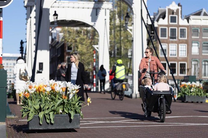 Archivo - Pearones y ciclistas en una calle de Ámsterdam, Países Bajos