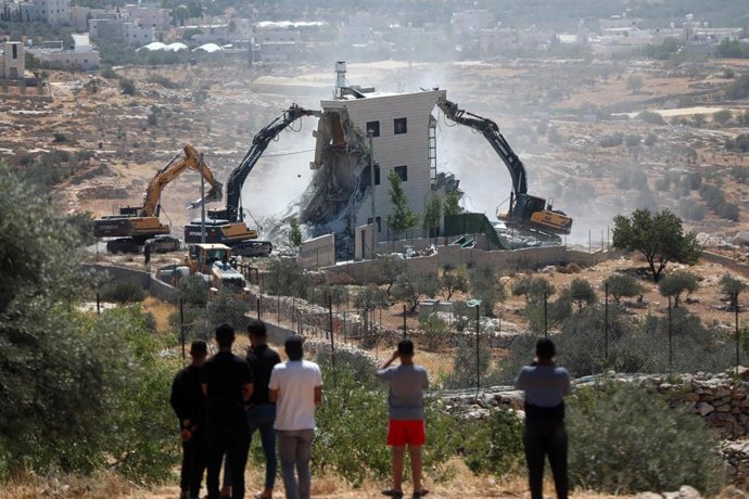 Archivo - Una excavadora derriba un edificio en Cisjordania