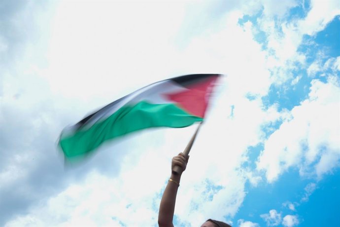 Archivo - 21 June 2025, US, New York: A woman waves a Palestinian flag at the Global March to Gaza and to Free Palestine in New York. Photo: Bryan Smith/ZUMA Press Wire/dpa