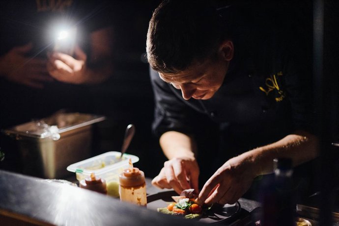 Archivo - 21 de novembro de 2024, Dnipro, Dnipropetrovsk Oblast, Ucrânia: Um chef do restaurante Mur Mur prepara cuidadosamente um prato sob a luz fraca de uma lanterna de smartphone durante um apagão. Os blecautes, causados por ataques de mísseis que têm