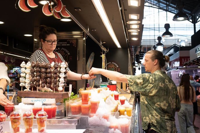 Archivo - Una persona compra en el mercado de la Boquería