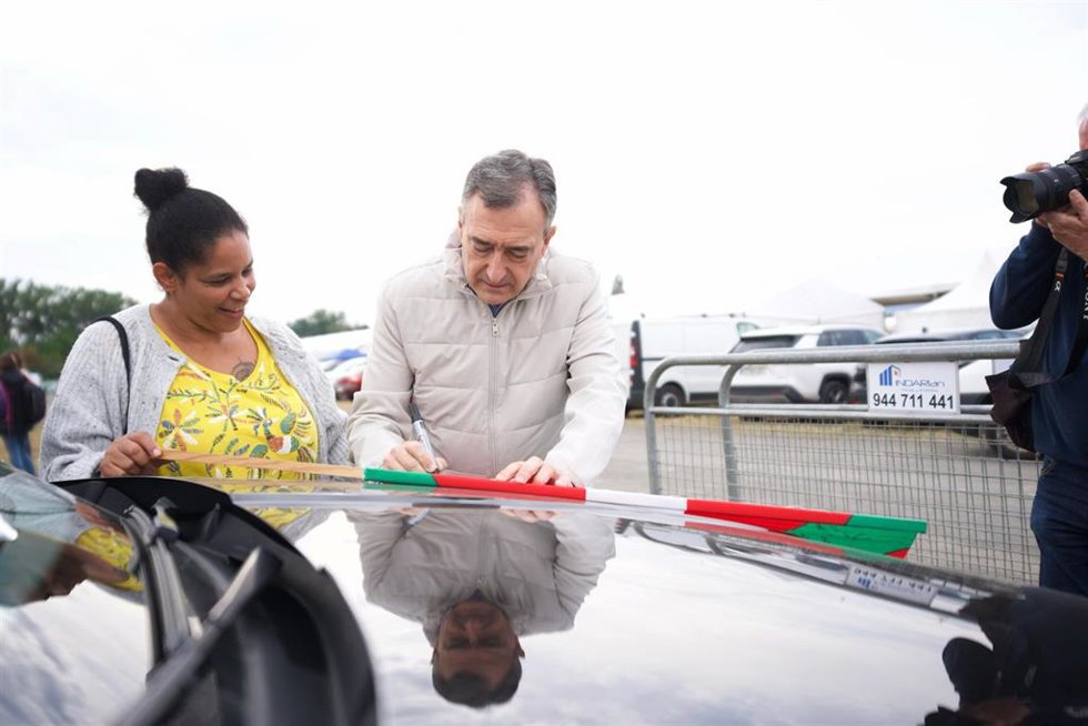 Esteban firma una ikurriña durante el 'Alderdi Eguna'