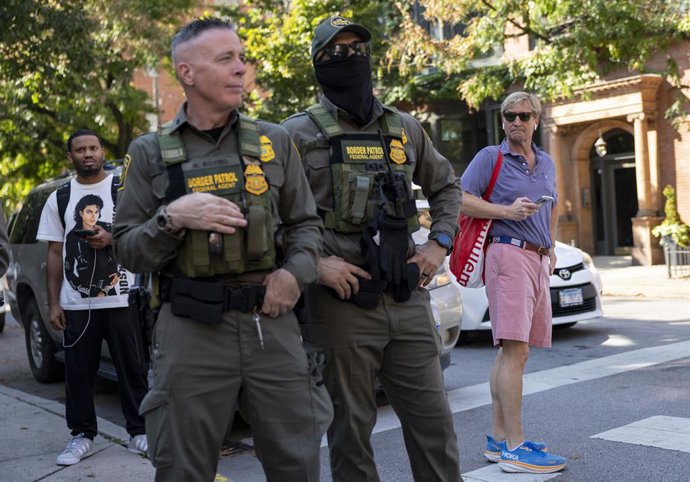 September 28, 2025, Chicago, Il, USA: Residents watch while Chief U.S. Border Patrol Agent Gregory Bovino, second from left, and other federal officers finish their march along North Clark Street by the Newberry Library in ChicagoĂ˘ââ˘s Gold Coast on S