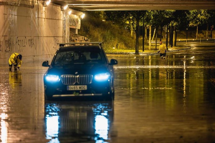 Un vehículo parado bajo paso inferior anegado por el agua de las tormentas registradas este domingo en Zaragoza y las localidades de alrededor.