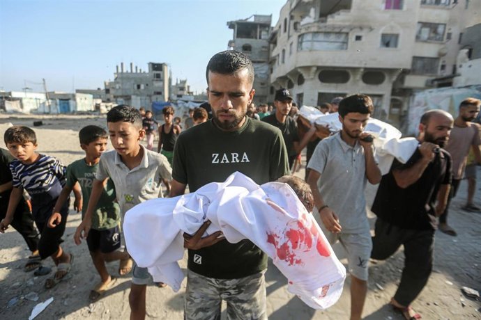 Palestinos trasladan los restos de varias personas muertas a causa de un bombardeo ejecutado por el Ejército de Israel contra la ciudad de Gaza, en el norte de la Franja de Gaza (archivo)