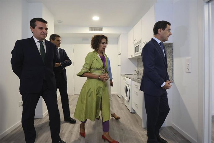 El presidente de Andalucía, Juanma Moreno; la vicepresidenta del Gobierno, María Jesús Montero, y el alcalde de Córdoba, José María Bellido, en el acto de entrega de llaves de la segunda fase de los alojamientos Sama Naharro para mayores en Córdoba.