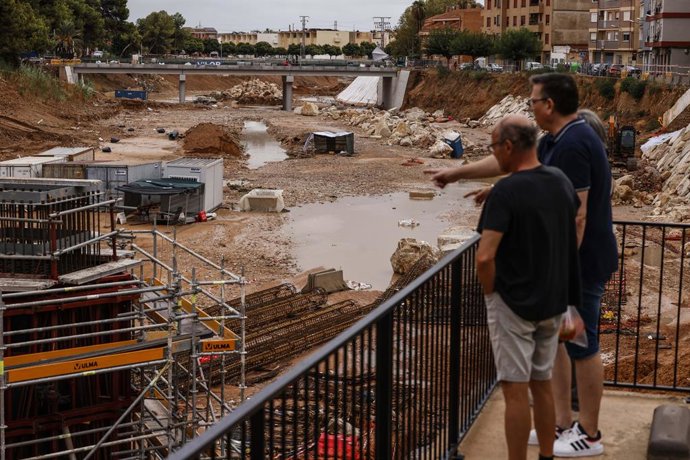 Dos hombres observan el barranco del Poyo tras las lluvias, a 29 de septiembre de 2025, en Paiporta, Valencia, Comunidad Valenciana (España). El barranco de La Saleta, en Aldaia (Valencia), se ha desbordado de madrugada, a la altura del dique de Bonaire, 
