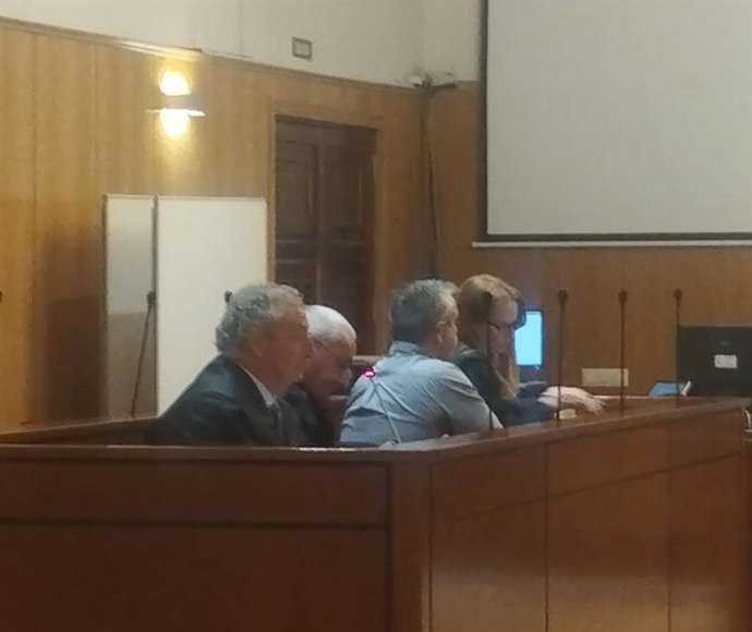 El camionero acusado, de espaldas, entre los abogados defensores.