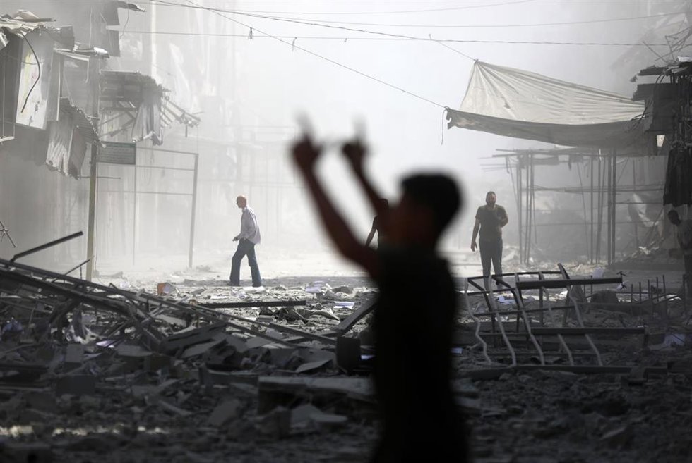 Varios alestinos observan la destrucción causada por un ataque aéreo israelí contra el Banco de Palestina en la Franja de Gaza, que quedó completamente destruido, mientras que otras estructuras cercanas resultaron dañadas.